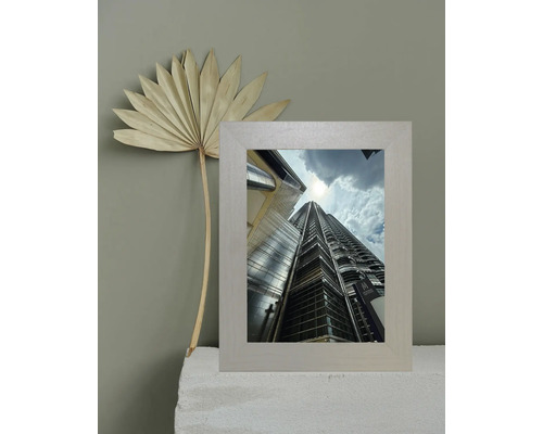 Dekorativer Bilderrahmen mit einem Foto der Petronas Towers und einem getrockneten Palmenblatt