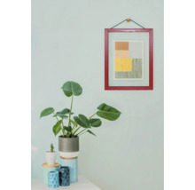 Dekorative Innenraumszene mit Zimmerpflanze und gerahmtem Bild an der Wand