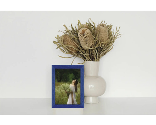 Dekorative Szene mit blauem Bilderrahmen, Vase und Blumenstrauß