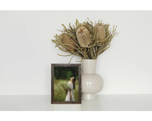 Dekorative Szene mit Bilderrahmen, Vase und Trockenblumenarrangement