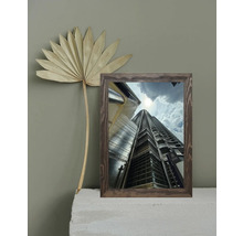 Dekoratives gerahmtes Wolkenkratzerbild neben einem Fächerblatt