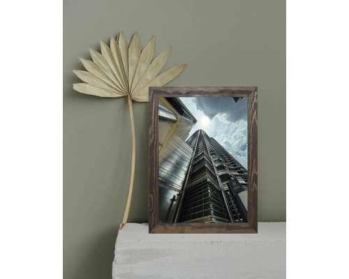 Dekoratives gerahmtes Wolkenkratzerbild neben einem Fächerblatt