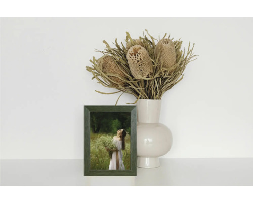 Dekoratives Stillleben mit Bilderrahmen, Vase und Trockenblumen