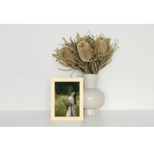 Dekoratives Stillleben mit einem Holzrahmen, einer Blumenvase und Trockenblumen