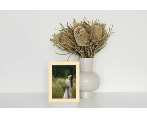 Dekoratives Stillleben mit einem Holzrahmen, einer Blumenvase und Trockenblumen