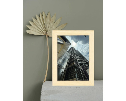 Bilderrahmen mit Hochhausmotiv und getrocknetem Palmenblatt