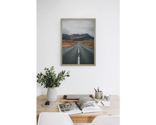 Gerahmtes Bild mit einer Straße, die zu Bergen führt.