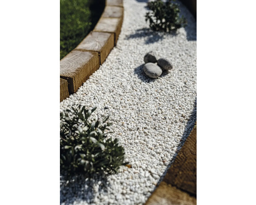 Vue détaillée d'un chemin de jardin avec bordure en bois et gravillons décoratifs