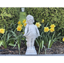 Vue de jardin avec figurine de fille en pierre et jonquilles jaunes