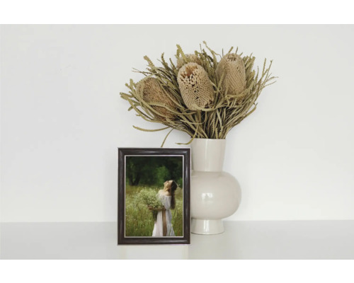 Dekoratives Stillleben mit Bilderrahmen, Blumen und Vase