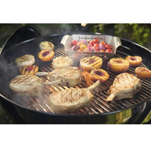 Barbecue avec côtelettes de porc, pêches, oignons et tomates sur le gril