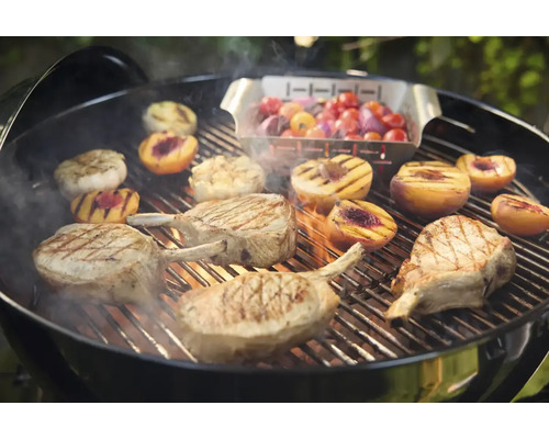 Barbecue avec côtelettes de porc, pêches, oignons et tomates sur le gril