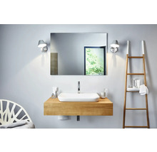 Salle de bains avec lavabo, miroir, appliques murales et échelle à serviettes