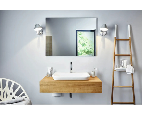 Salle de bains avec lavabo, miroir, appliques murales et échelle à serviettes