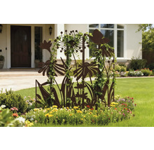 Aménagement décoratif de jardin avec support pour plantes grimpantes en forme de fleurs et plantes grimpantes devant une façade de maison