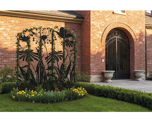 Scène de jardin avec support pour plantes en métal, fleurs et mur de briques