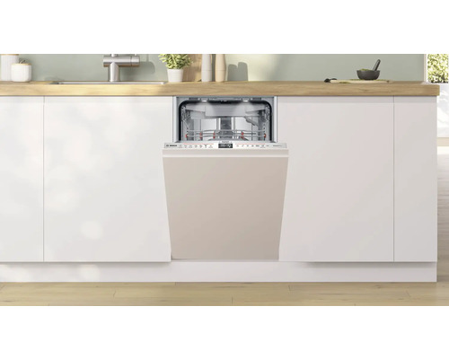 Lave-vaisselle intégré dans une cuisine moderne avec des armoires blanches et un plan de travail clair.