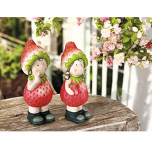 Zwei Erdbeerfiguren als Gartendekoration auf einem Holztisch