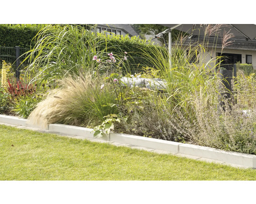 Gestalteter Garten mit Rasenfläche und bepflanztem Beet