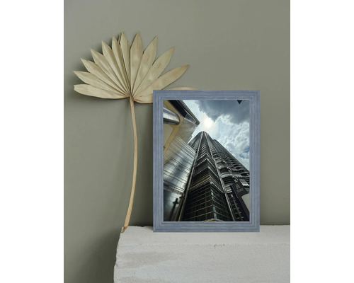Gerahmtes Bild eines Wolkenkratzers mit Palmenblattdekoration