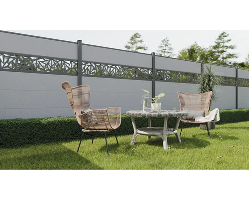 Scène de jardin avec clôtures en béton, fauteuils en rotin et table d'appoint sur une pelouse.