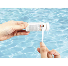 Analyse de l'eau de piscine avec des bandelettes de test.