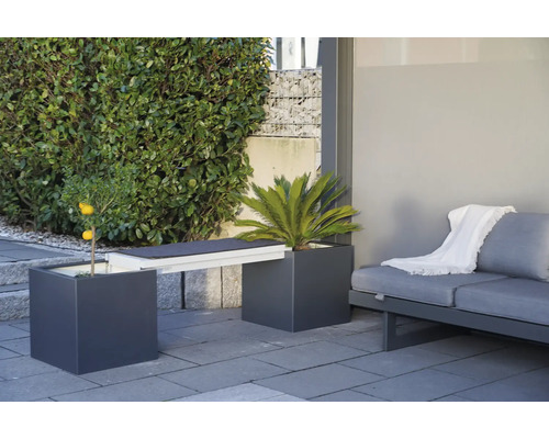 Gartenmöbelanordnung mit Pflanzgefässen, die als Bank dienen, und einem Sofa auf einer Terrasse.