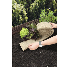 Gemüsegarten mit Salatpflanzen und einer Rolle Pflanzmatte aus Naturfasern auf dem Boden.