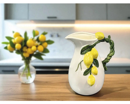 Dekorative Keramikkanne mit Zitronenverzierung auf einem Tisch in der Küche