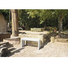 Vue du jardin avec fontaine en pierre et un banc blanc