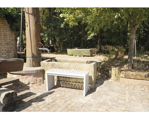 Vue du jardin avec fontaine en pierre et un banc blanc