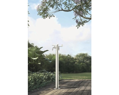 Gartenszene mit freistehender Wasserzapfsäule aus Metall auf einer Holzterrasse