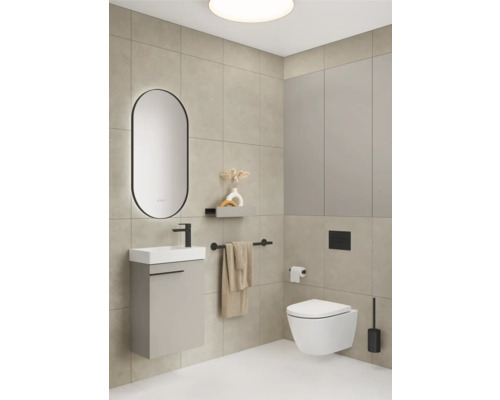 Badezimmer mit Waschtisch, Spiegel, Toilette und Handtuchhalter