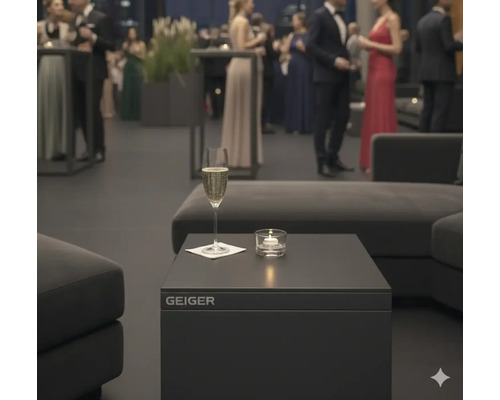 Szene mit Geiger-Tisch, Sektglas und Kerze bei einer Veranstaltung