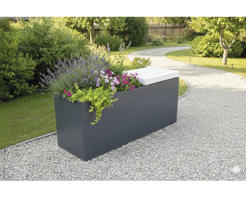 Banc de jardin avec jardinière et fleurs dans un jardin avec un chemin de gravier.