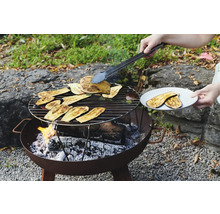 Barbecue avec des tranches d'aubergine et des pinces à barbecue dans le jardin.