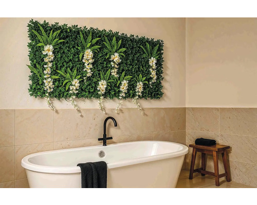 Badezimmer mit Badewanne, Hocker und Pflanzenwand