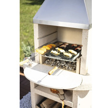 Barbecue en maçonnerie avec des aliments grillés et des accessoires dans le jardin