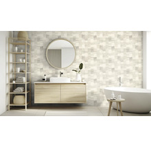 Salle de bains avec lavabo, miroir, étagère et baignoire devant un mur à motifs carrés.