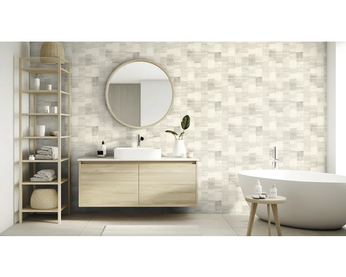 Salle de bains avec lavabo, miroir, étagère et baignoire devant un mur à motifs carrés.