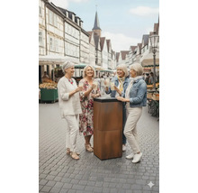 Vier Frauen stehen im Freien an einem Stehtisch und halten Getränke.