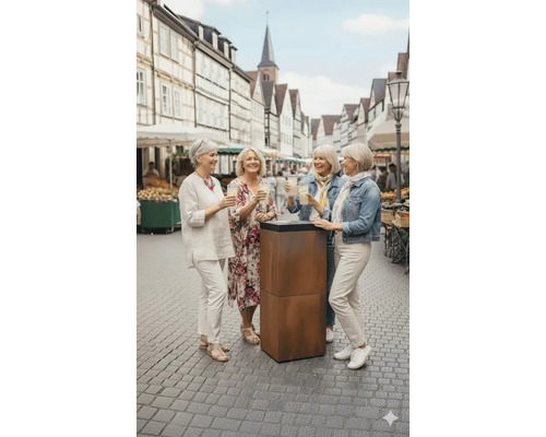 Vier Frauen stehen im Freien an einem Stehtisch und halten Getränke.