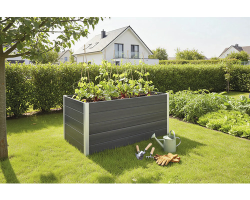 Hochbeet klassisch WPC 150 x 70 x 75 cm anthrazit Hochbeet aus Kunststoff mit Pflanzen, Giesskanne und Gartengeräten im Garten.