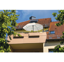 Parasol rayé sur un balcon devant une maison