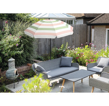 Ensemble de meubles de jardin avec parasol, canapé, fauteuils et table à l'extérieur.
