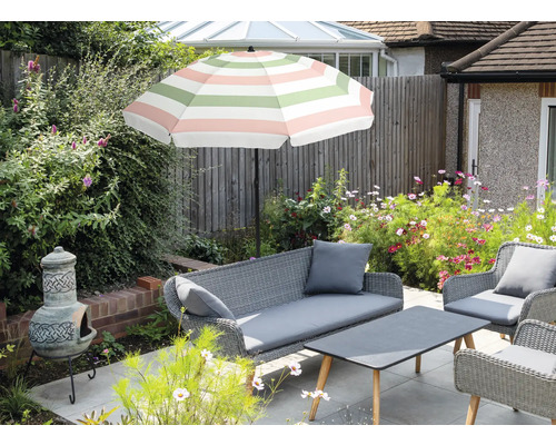Ensemble de meubles de jardin avec parasol, canapé, fauteuils et table à l'extérieur.