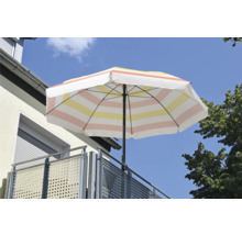 Parasol rayé sur un balcon avec garde-corps métallique.