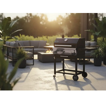 Scène de jardin avec barbecue à charbon de bois, coin salon et foyer pour une ambiance extérieure conviviale.