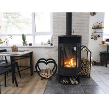 Salon avec poêle à bois, bois de chauffage et table à manger