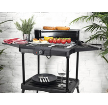 Barbecue électrique avec aliments grillés, vaisselle et plantes sur un balcon